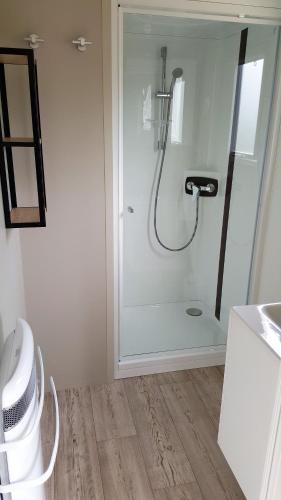 une salle de bain avec une douche avec une porte vitrée dans l'établissement Camping Caravaning Les Cerisiers Berck sur mer, à Verton