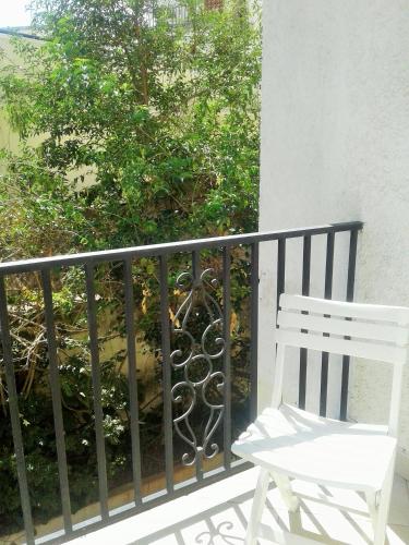 a white chair sitting on a balcony next to a tree at Résidence Le Hublot in Antananarivo