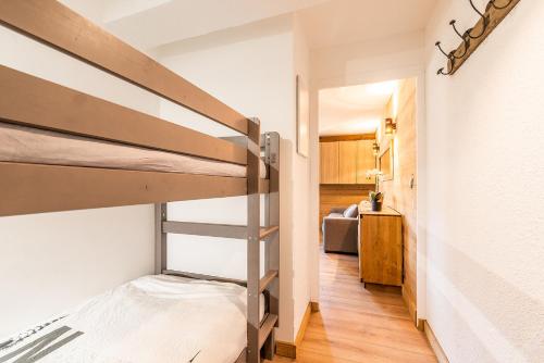 a room with two bunk beds and a hallway at Fleur des Montagnes in Praz-sur-Arly