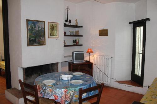a dining room with a table and a tv at Appartamento La Perla a soli 100m dal mare a Marina di Castagneto in Marina di Castagneto Carducci