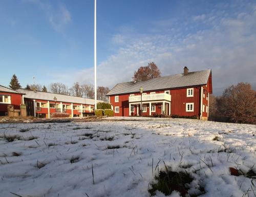 un grand bâtiment rouge avec de la neige devant lui dans l'établissement Breanäs Hotell, à Immeln
