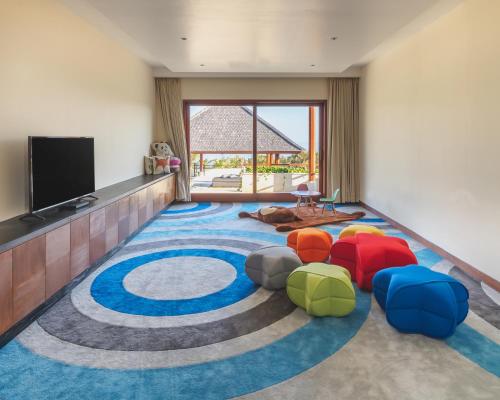 a living room with colorful chairs on a large rug at The Edge Bali in Uluwatu