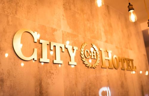 a sign on a wall that reads city light at CITY HOTEL in Ferizaj