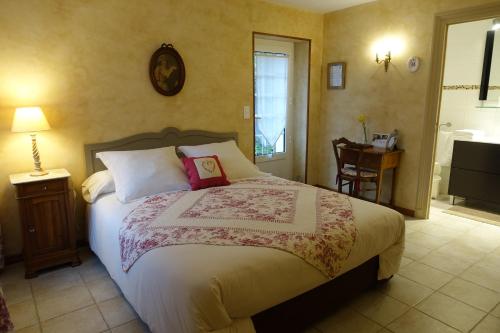 Dormitorio con cama, escritorio y TV en Le Clos des Bérengeries, en Saint-Patrice