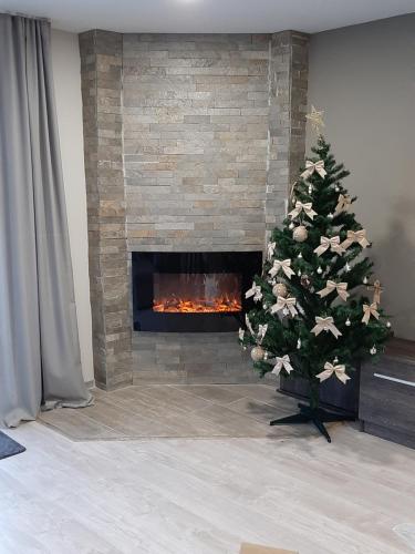 a christmas tree in a living room with a fireplace at Villa Gardenia in Sapareva Banya