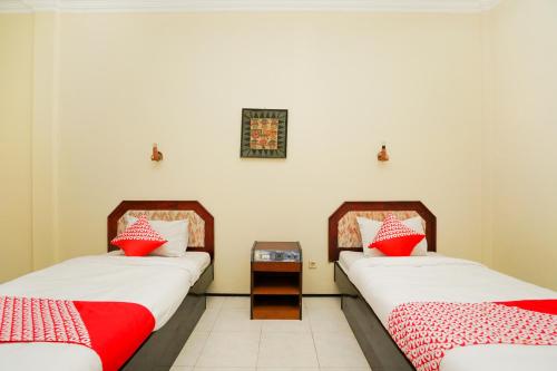 two beds sitting next to each other in a room at OYO 1652 Hotel Tampiarto in Probolinggo