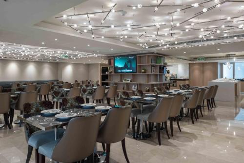 a dining room with tables and chairs and a flat screen tv at K Hotel Taipei Chang-An in Taipei