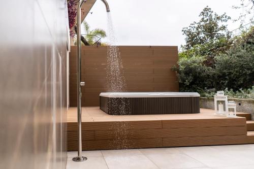 a hot tub in a garden with a fountain at Sicilia's Art Hotel & Spa in Acitrezza