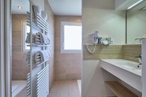 a bathroom with a sink and a mirror at Les Villas d'Arromanches, Teritoria in Arromanches-les-Bains