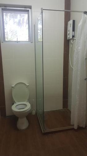 a bathroom with a toilet and a glass shower at Bellevue The Penang Hill Hotel, Bukit Bendera in Ayer Itam