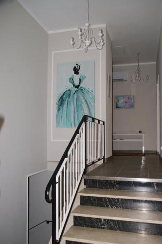 a staircase with a picture of a dress on the wall at LA DAMA ROOM&BREAKFAST in Russi