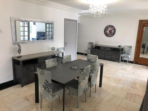 une salle à manger avec une table et des chaises noires dans l'établissement Grand appartement de standing 
