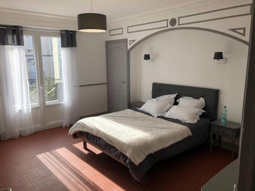 - une chambre avec un lit et une arche au-dessus dans l'établissement Grand appartement de standing 