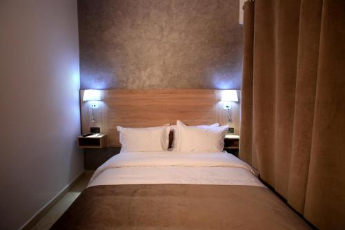 a bedroom with a large bed with two pillows at Hotel Ichbilia فندق اشبيلية in Marrakech