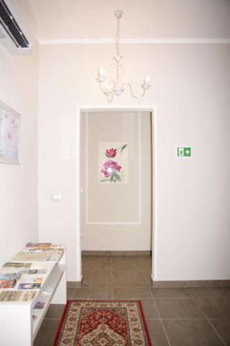 a room with a white door with a rug and a chandelier at LA DAMA ROOM&BREAKFAST in Russi
