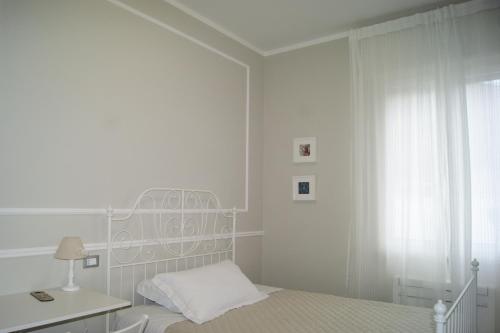 a white bedroom with a bed and a desk at LA DAMA ROOM&BREAKFAST in Russi