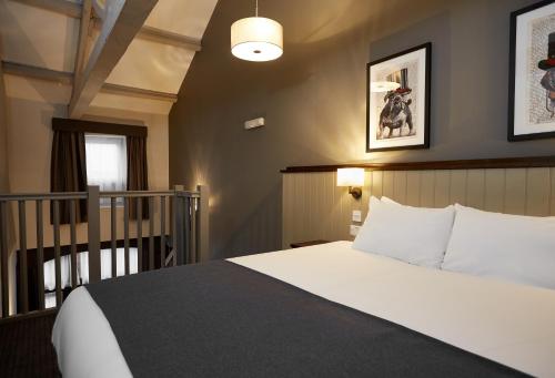 a hotel room with a bed and a staircase at Kings Head by Chef & Brewer Collection in Masham