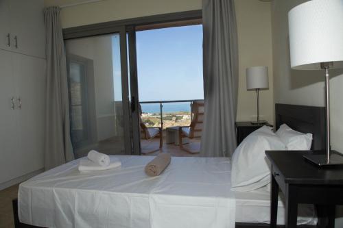 a hotel room with a bed with towels on it at Lagada Resort in Makry Gialos