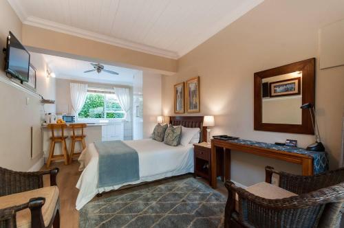 um quarto com uma cama, uma secretária e uma janela em Margate Place Guest House em Port Elizabeth