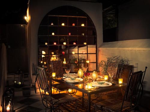 una mesa con velas y sillas en una habitación en Riad Dar Jaguar, en Marrakech