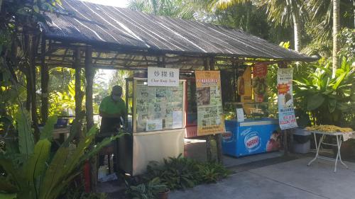 a man standing next to a food stand with signs at Bellevue The Penang Hill Hotel, Bukit Bendera in Ayer Itam
