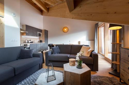 a living room with two couches and a table at TERRESENS - Le Saphir in Vaujany
