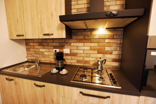 a kitchen with a stove and a brick wall at La casetta di Anastasia in Rome