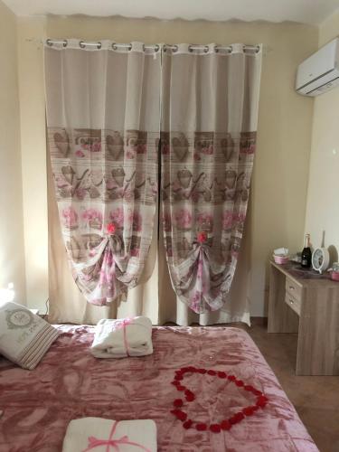 a bedroom with a bed and a window with curtains at B&B la reggia in Caserta