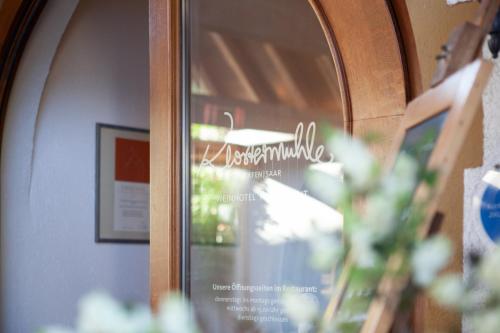 a mirror with a reflection of a restaurant sign at Weinhotel Restaurant Klostermühle in Ockfen