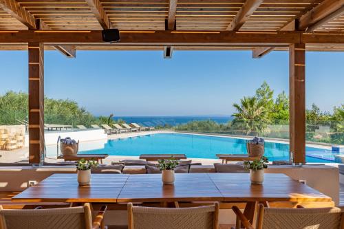 a view of a pool from a restaurant with tables and chairs at Paliokaliva Apartments and Villas in Tsilivi