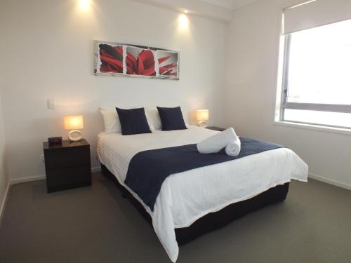a bedroom with a large bed and a window at Pacific Marina Apartments in Coffs Harbour