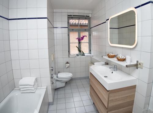 a white bathroom with a sink and a toilet at Lutherwohnung in Schmalkalden