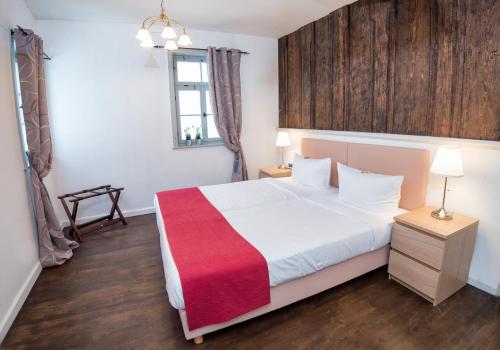 a bedroom with a bed with a red blanket on it at Lutherwohnung in Schmalkalden