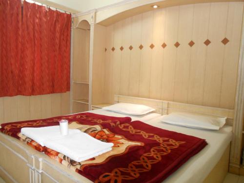 a bed room with a white bedspread and a red curtain at Hotel Sheela, 100m from Taj Mahal in Agra