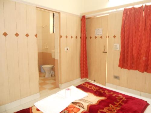 a bathroom with a toilet and a red curtain at Hotel Sheela, 100m from Taj Mahal in Agra