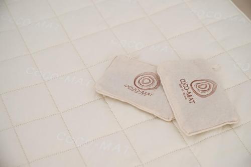 two towels sitting on top of a white tile floor at Nefeli Apartments in Ayia Evfimia