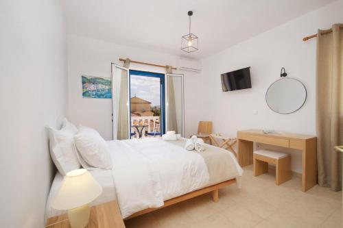 a bedroom with a bed and a table and a window at Nefeli Apartments in Ayia Evfimia