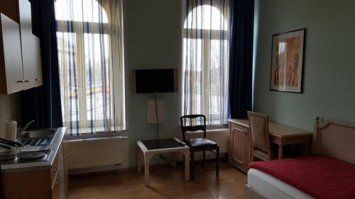 a bedroom with a bed and a desk with a chair at Apartments in der Friedrich Ebert Straße 90 Sportforum in Leipzig
