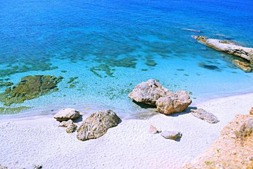 a beach with rocks and the blue water at Marmari View in Marmarion