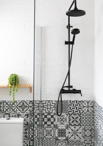 a bathroom with a shower with black and white tiles at Villa Marina in Denia
