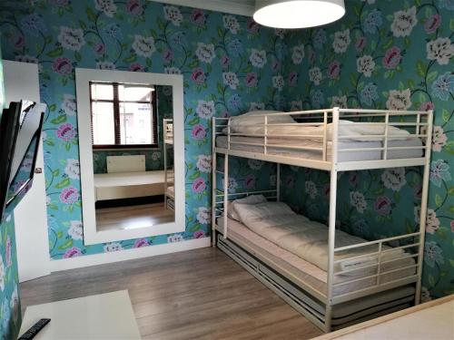 a bedroom with bunk beds and a mirror at Kwiatowa Bryza in Gdańsk
