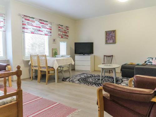 ein Wohnzimmer mit einem Tisch, einem Sofa und einem TV in der Unterkunft Holiday Home Itäkoski 2 by Interhome in Itäkoski