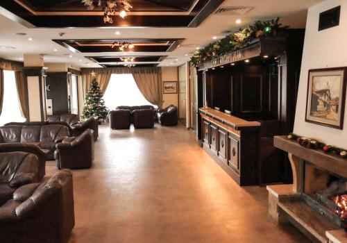 a large living room with leather furniture and a christmas tree at Park Hotel Panorama in Bansko