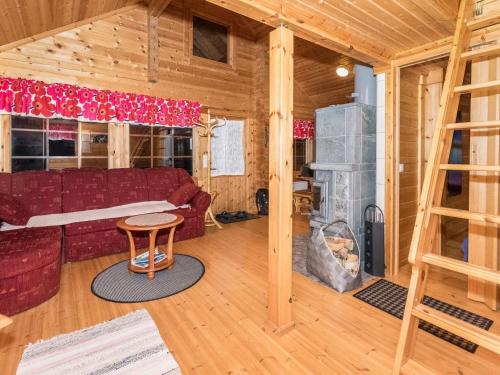 salon z czerwoną kanapą i kominkiem w obiekcie Holiday Home Käenpesä by Interhome w mieście Iisalmi