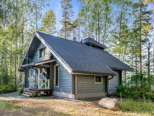 a small blue house in the woods at Holiday Home Villa populus by Interhome in Pertunmaa