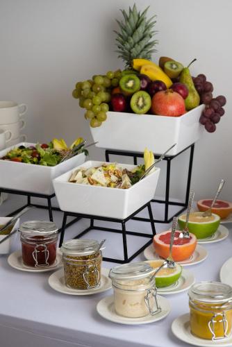 a table topped with bowls of fruits and vegetables at Enklawa Białowieska Forest & Spa in Hajnówka
