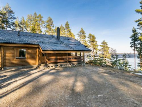 a log cabin with a driveway in front of a house at Holiday Home Roopenranta by Interhome in Asikkala