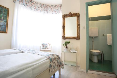 a bedroom with a bed and a mirror and a toilet at Antiche Mura in Riva del Garda