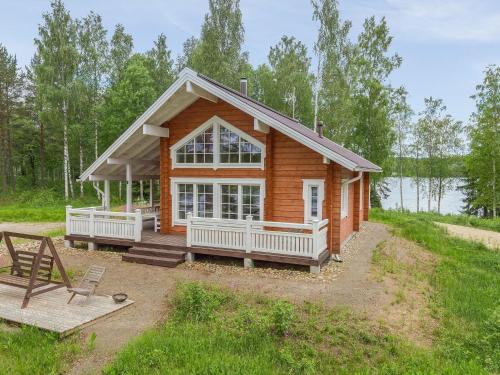 Cabaña de madera con porche y ventana grande en Holiday Home Paavolanniemi by Interhome en Kotalahti