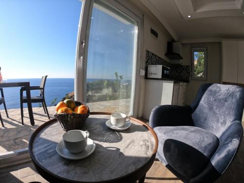 a table with a bowl of fruit and a view of the ocean at Blue Lagoon Village in Gazipasa